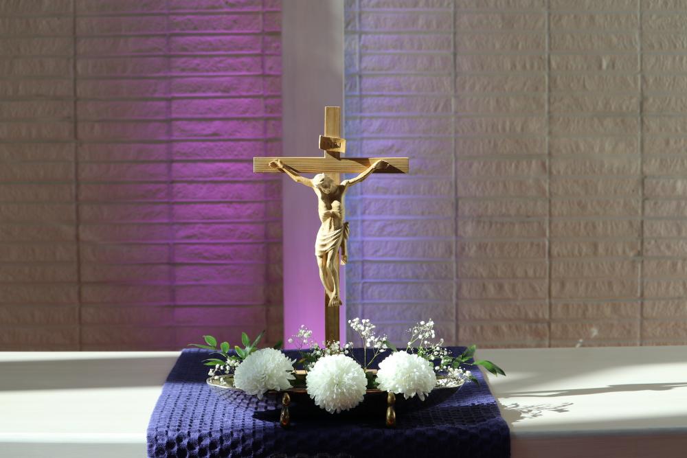Pyhäjoen kirkon alttari, jossa lähikuvassa krusifiksi ja liturgisena värinä violetti.